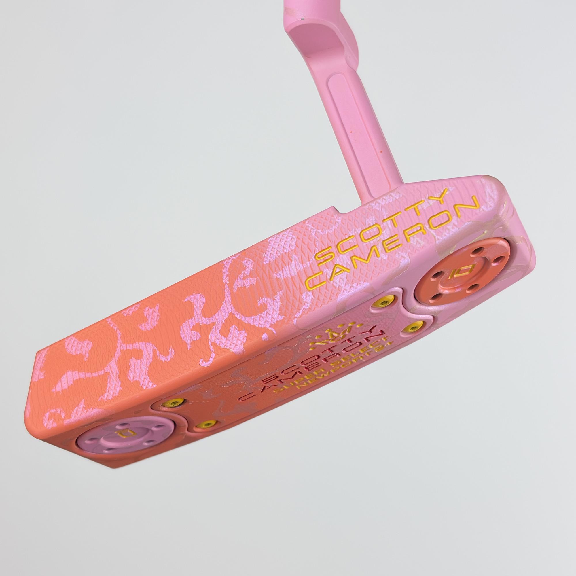 Custom painted Newport 2 Plus from the face side at an angle, coral fading to pink with a floral pattern and the Scotty Cameron stamp in gold.