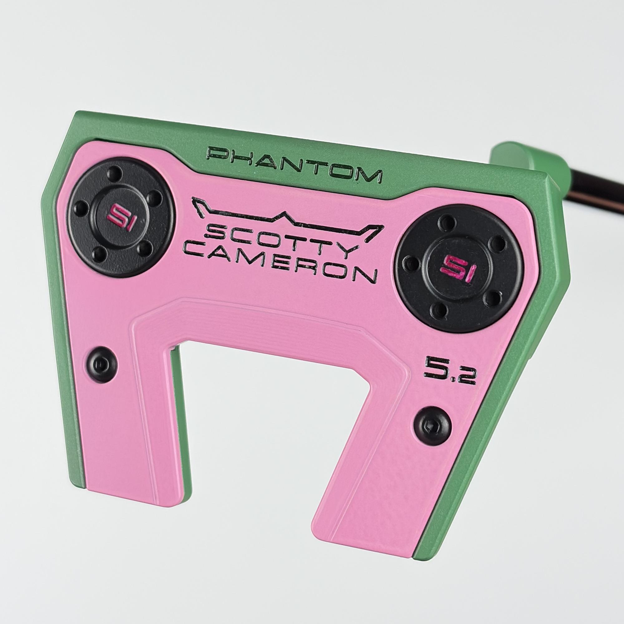 Sole of the custom painted Scotty Cameron Phantom 5.2, a pink sole plate stamped Phantom, Scotty Cameron and 5.2, framed by green rails.