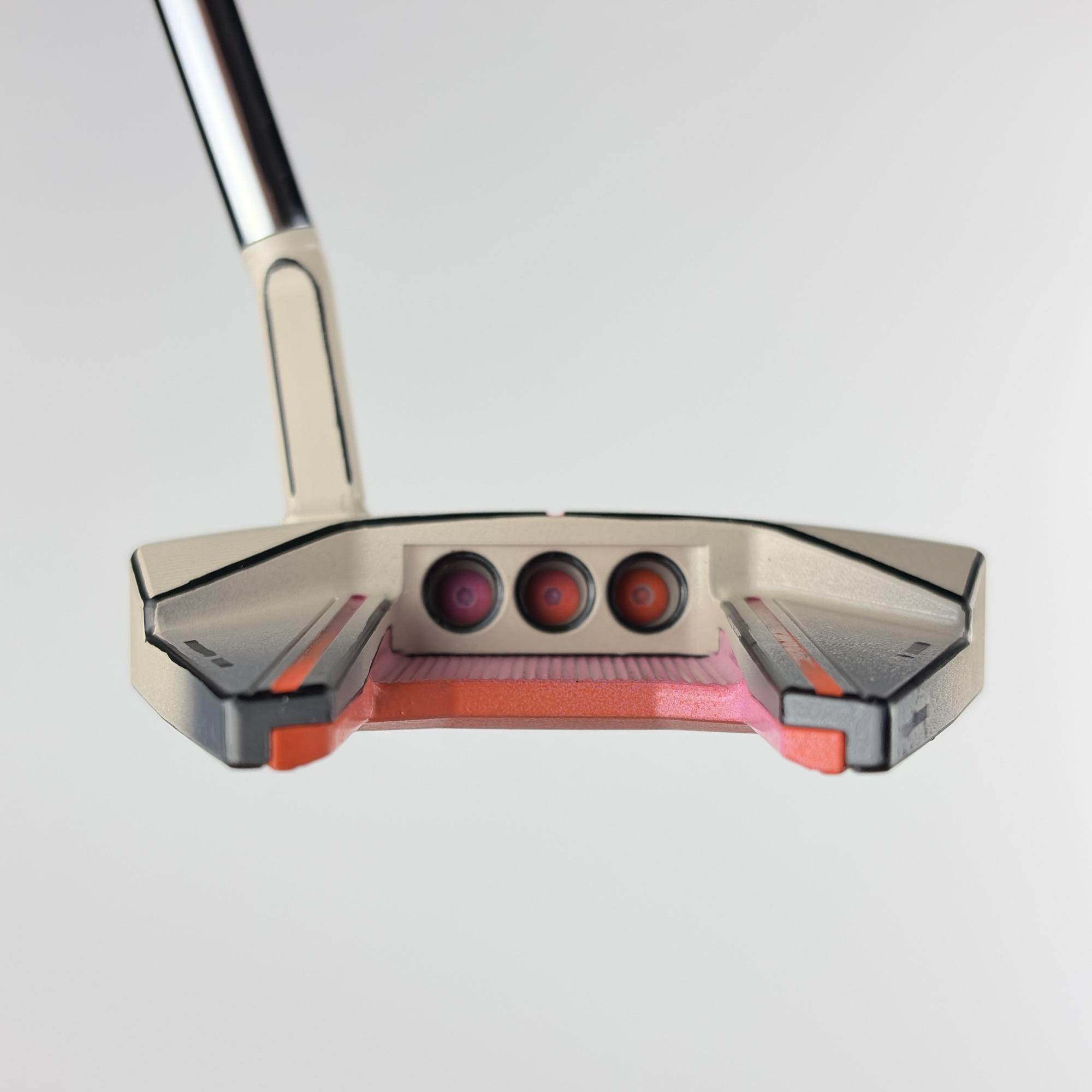 Custom painted Phantom 7.5 at address, sand body with coral flanges and three topline sight dots.